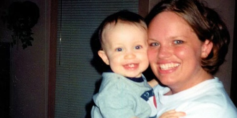 Baby picture of Zach Mullins being held by his mother with a smiling face