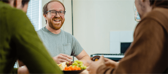 Hemophilia A patient, Billy Eshleman, smiling with two people sitting across from him.