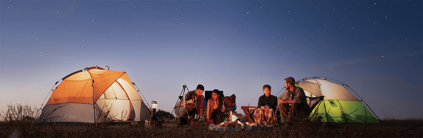 Family camping sitting around a bonfire A family camping sitting around a bonfire